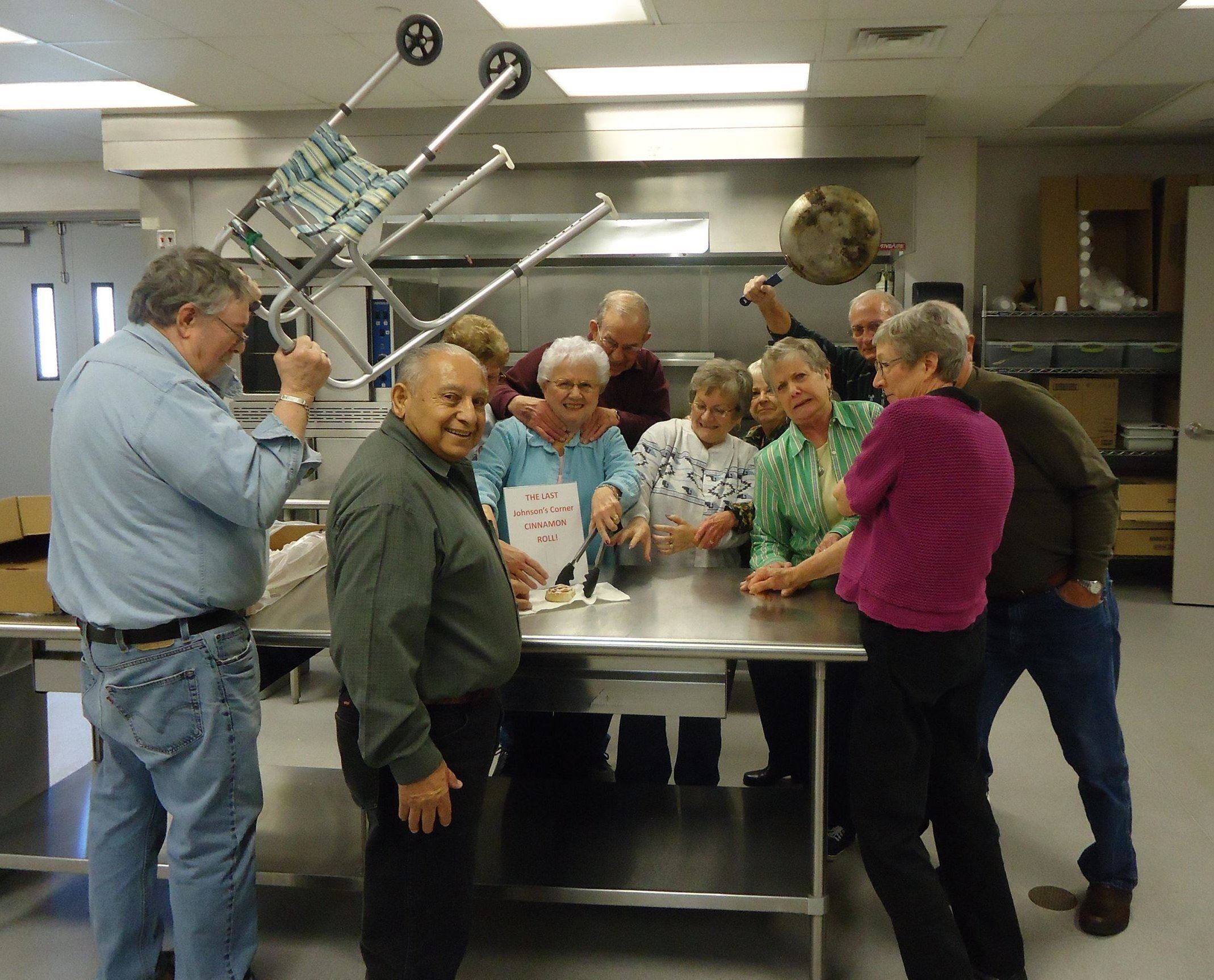A group of older adults standing around a table
