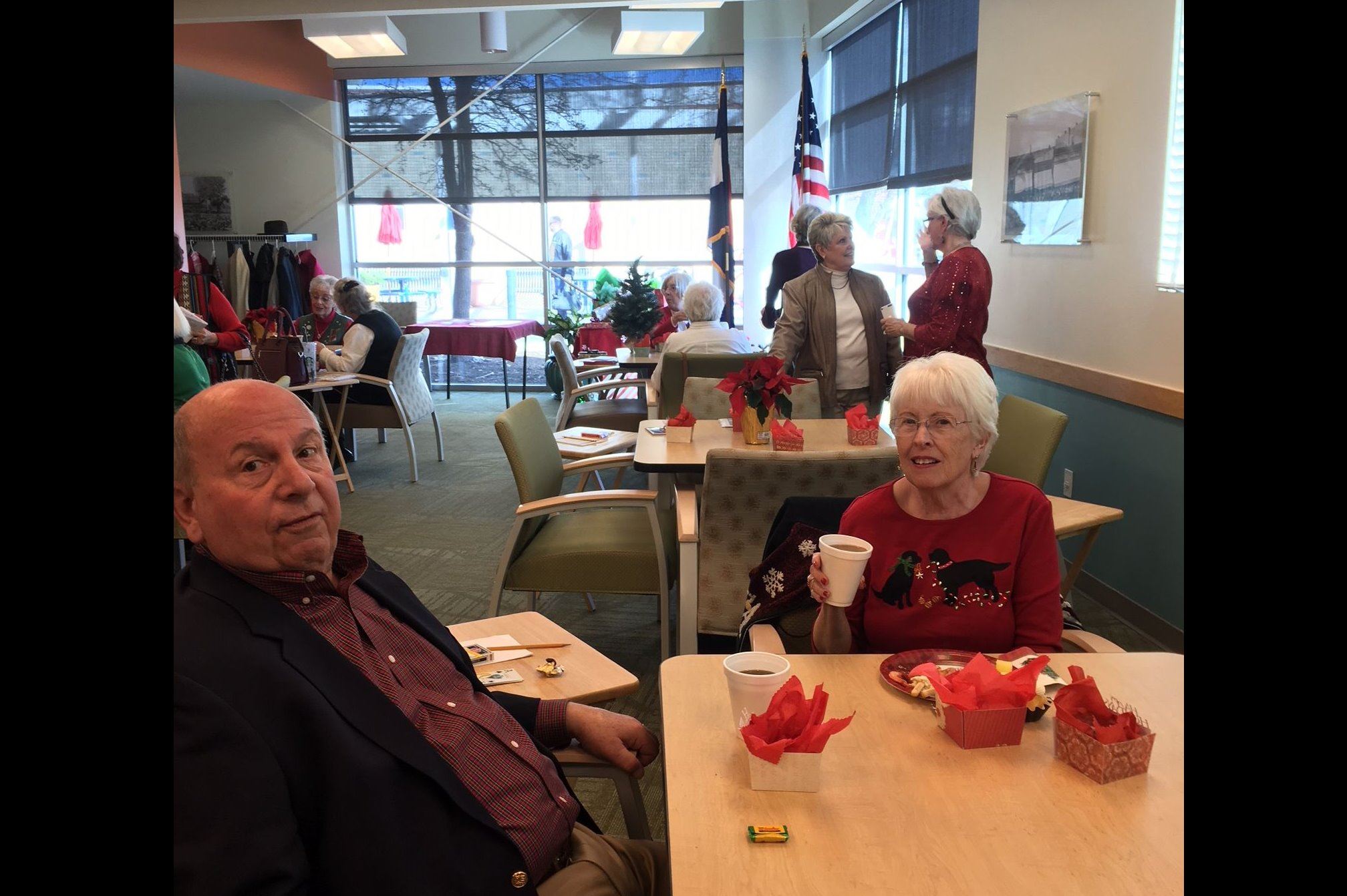 An older man and woman drinking coffee at a table together