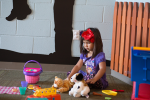 A young child playing with toys while sitting on a floor