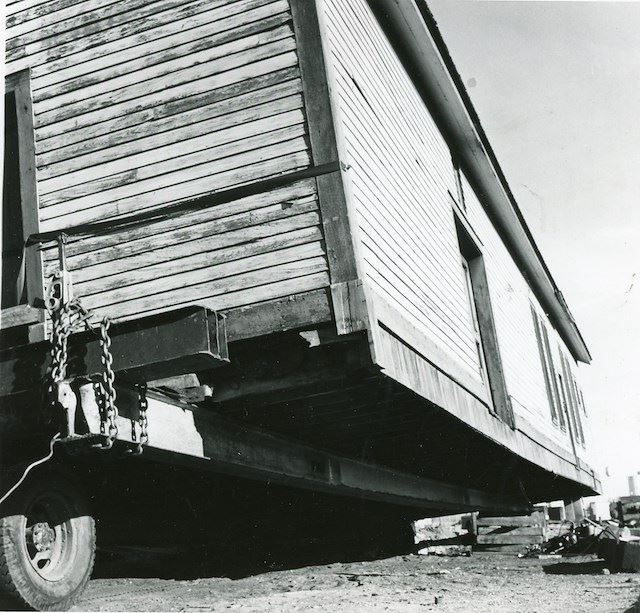 Black and white photograph of the train depot being moved.