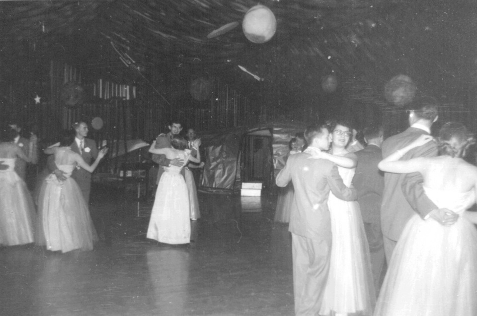 Black and white photograph of couples dancing in the gymnasium.